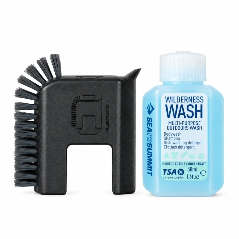 Black Sea to Summit Camp Kitchen pot scrubber beside a blue 50 ml Wilderness Wash bottle on white.